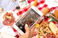 Woman takes a photo on her mobile phone durring outdoor picnic Royalty Free Stock Photo