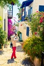 Woman takes picture of picturesque house on the street of Kalkan in Turkey