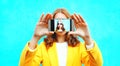 woman takes picture self portrait on smartphone on colorful blue Royalty Free Stock Photo
