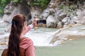 Woman takes pictures of the mountain river on the phone