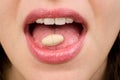 Woman takes pills on tongue