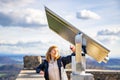 Woman takes a selfie of city Singen from observation deck with telescope of castle Hochnetwil