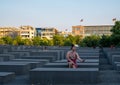 Woman takes selfie at the Memorial to the Murdered Jews of Europe in Berlin Germany designed by Peter Eisenman.