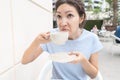 Woman takes a sip of coffee and makes disgusting grimace. The concept of bad smell or trouble waking up and insomnia