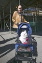 Woman takes white dog in baby buggy for a walk down Central Park in Manhattan, New York City, New York Royalty Free Stock Photo