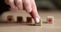 Woman takes wooden cube with green star putting forward