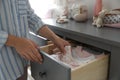 Woman taking baby clothes from open cabinet drawer in child room Royalty Free Stock Photo