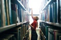 Woman taking book from library bookshelf Royalty Free Stock Photo