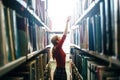 Woman taking book from library bookshelf Royalty Free Stock Photo