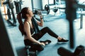 Woman taking a break and  drinking water after workout at gym Royalty Free Stock Photo