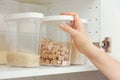 Woman taking brown cane sugar from a kitchen cupboard Royalty Free Stock Photo