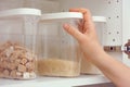 Woman taking brown rice from a kitchen cupboard Royalty Free Stock Photo