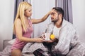 Woman taking care of her sick boyfriend lying in the bed Royalty Free Stock Photo