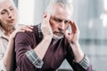 Woman taking care of husband with strong headache at home Royalty Free Stock Photo