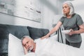 Woman taking care of sick husband in bed Royalty Free Stock Photo