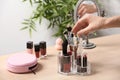 Woman taking cosmetic products for makeup from organizer on dressing table, closeup. Royalty Free Stock Photo