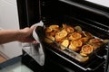 Woman taking delicious lemon chicken out of oven Royalty Free Stock Photo