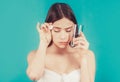 Woman taking drugs to releave headache. Brunette take some pills, holds glass of water, isolated on blue Royalty Free Stock Photo