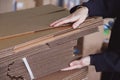 Woman taking folded stacks of corrugated cardboards for packing in warehouse Royalty Free Stock Photo