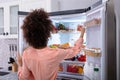 Woman Taking Food From Refrigerator