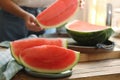 Woman taking fresh fruit indoors, focus on slices of juicy watermelon