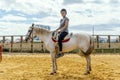 A woman taking horse riding lessons in a paddock Royalty Free Stock Photo