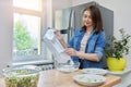 Woman taking ice cubes into bowl in kitchen