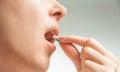 Woman taking a medical capsule or vitamin.