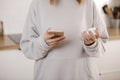 Woman Taking Medicine. Young woman Holding bottle With Pills In Hand And Reading Medical Instructions in the cellphone Royalty Free Stock Photo