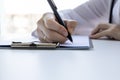 A woman is taking notes. Hand of university student using pen and writing in notebook, exam preparation, presentation Royalty Free Stock Photo