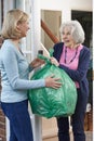 Woman Taking Out Trash For Elderly Neighbour