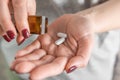 Woman taking painkiller white pills or antibiotic on female hand pouring tablets from meds bottle. Taking medicine Royalty Free Stock Photo