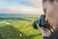 Woman taking a photo with a camera high in the sky flying in a hot air balloon