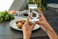 Woman taking photo of chicken salad with mobile phone, closeup Royalty Free Stock Photo