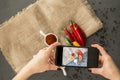 Woman taking a photo of chili peppers and spices