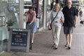 A woman is taking a photo of a funny sandwich board. Royalty Free Stock Photo