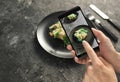 Woman taking photo of healthy salad with mobile phone, closeup Royalty Free Stock Photo