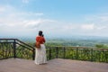 Woman taking photo with her phone of scenic countryside from a lookout