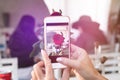 Woman taking photo of rose on her smartphone. Royalty Free Stock Photo