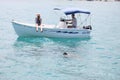 Woman taking a photo of a sea turtle from a small boat