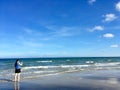 Woman taking photo with smartphone at empty sea beach