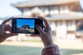 Woman taking photo by Smartphone at Todaiji temple, Asian traveler visit in Nara near Osaka. landmark and popular for tourists