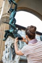 Woman taking photo of statue perseus in florence