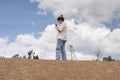 Woman taking a photo from the top of a barren hill Royalty Free Stock Photo