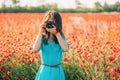 Woman taking photographs with camera in meadow. Royalty Free Stock Photo