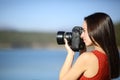 Woman taking photos with dslr camera in a lake Royalty Free Stock Photo