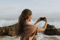 Woman taking photos with her phone on the beach Royalty Free Stock Photo