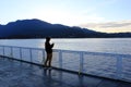 Woman taking photos with her smartphone while standing on the deck of a ferry boat Royalty Free Stock Photo