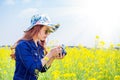 Woman taking photos at a rapeseed flowers.