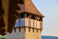 Woman taking photos up in a tower, in the fortified Evangelical church of Alma Vii, Transylvania, Romania, with warm sun setting.